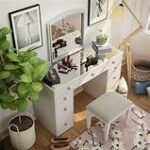 White vanity dressing table with large mirror and storage drawers for makeup and accessories.