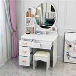 White vanity dressing table with large mirror and storage drawers for makeup and accessories.